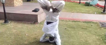 MLA Does Headstand Outside Assembly